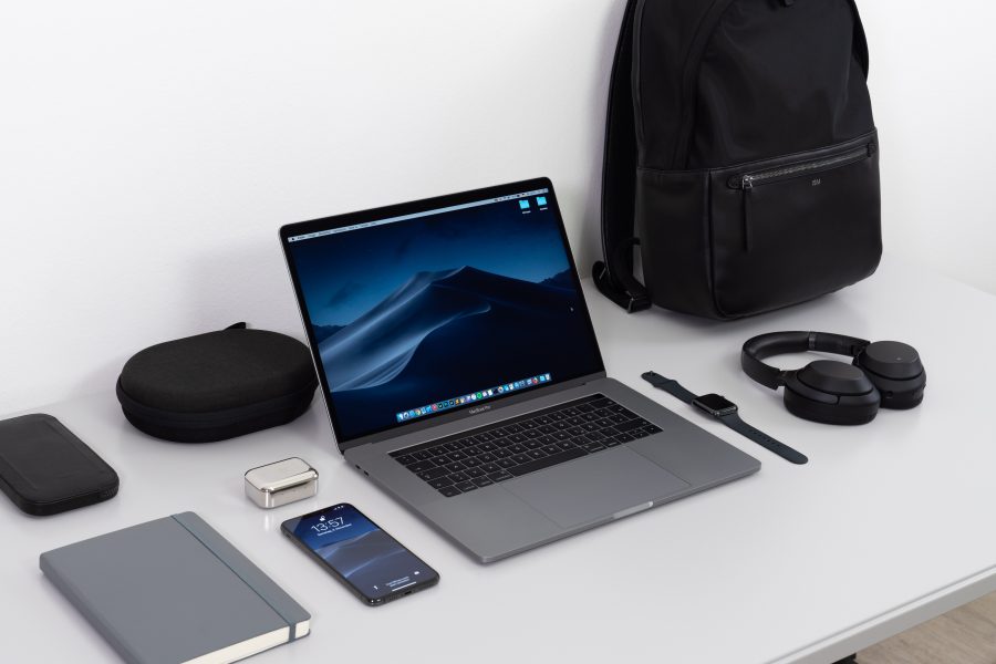 Laptop on desk with smart phone, headphones, smart watch